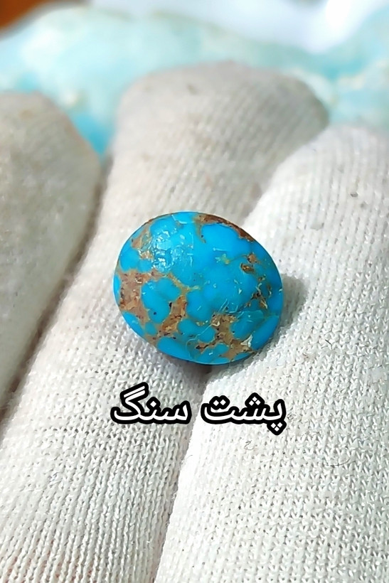 سنگ فیروزه عجمی نیشابوری، ذات عالی عجمی رگه دار با رگه های ظریف و منظم عنکبوتی، بسیار خوشرنگ و خوش نقش و نگار، رنگ کمیاب و جذاب آبی محک بسیار پررنگ و خیره کننده، جلای فوق العاده درخشان و آینه ای با پودر الماس، تراش بیضی دامله مغزدار و تمام فیروزه با خلوص بالا، مناسب برای کار روی طلا، انگشتر، دستبند و مدال، با ضمانت اصل نیشابور، زنده و طبیعی.