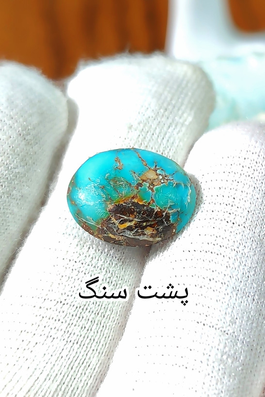 سنگ فیروزه عجمی نیشابوری، ذات عالی عجمی رگه دار با رگه های ظریف ، بسیار خوشرنگ و خوش نقش و نگار، رنگ آبی با هاله ای از رنگ سبز خاص و خیره کننده، جلای فوق العاده درخشان و آینه ای با پودر الماس، تراش بیضی دامله مغزدار و تمام فیروزه با خلوص بالا، مناسب برای کار روی طلا، انگشتر، دستبند و مدال ، با ضمانت اصل نیشابور، زنده و طبیعی.