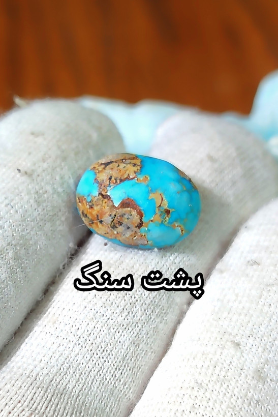 سنگ فیروزه عجمی نیشابوری، ذات عالی عجمی رگه دار با رگه های ظریف طلایی، بسیار خوشرنگ و خوش نقش و نگار، رنگ زیبا و جذاب آبی خاص Persian Blue، جلای فوق العاده درخشان و آینه ای با پودر الماس، تراش بیضی دامله مغزدار و تمام فیروزه با خلوص بالا، مناسب برای کار روی طلا، انگشتر، دستبند و مدال، با ضمانت اصل نیشابور، زنده و طبیعی.